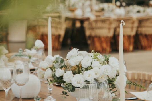 a table with white flowers and candles